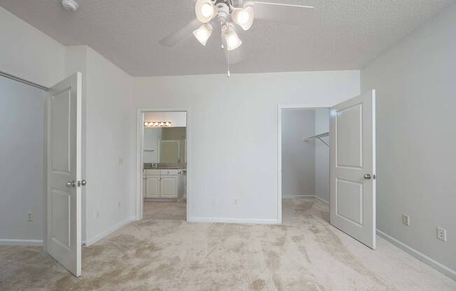 A room with a ceiling fan and carpeted floor.