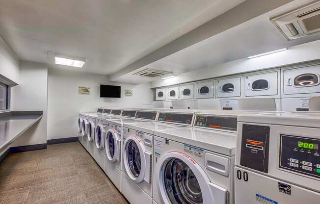 a washer and dryer closet in a laundry room with lots of washing machines