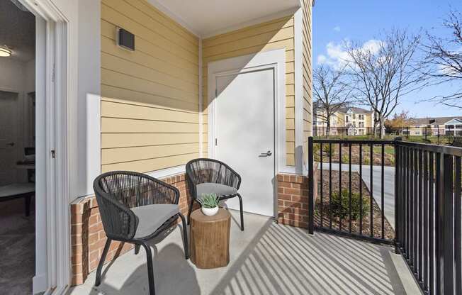 A patio with two chairs and a table.