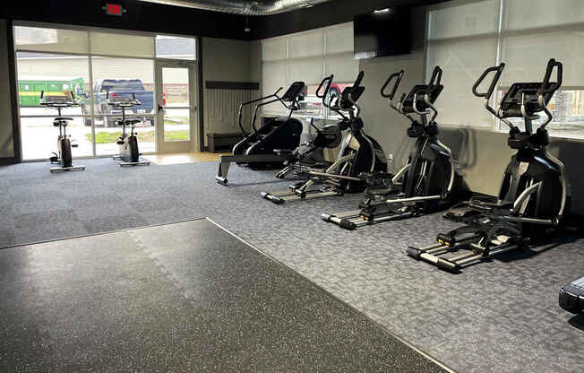 A gym with a row of stationary bikes.