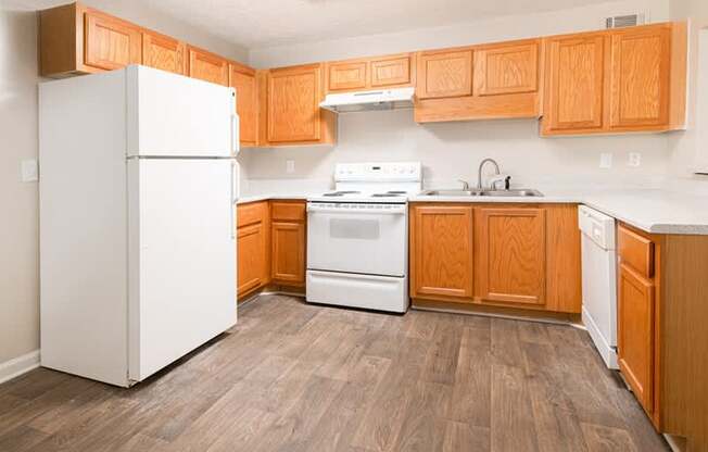 A kitchen with wooden cabinets and a white refrigerator.