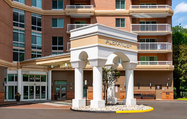 Alexander apartment building with a white arched entrance.