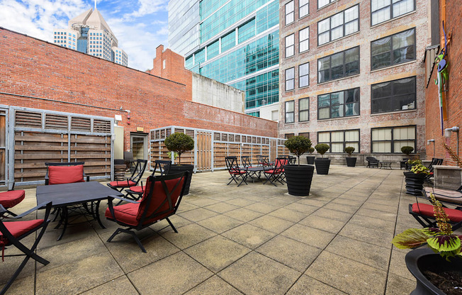 an outdoor patio with tables and chairs and tall buildings