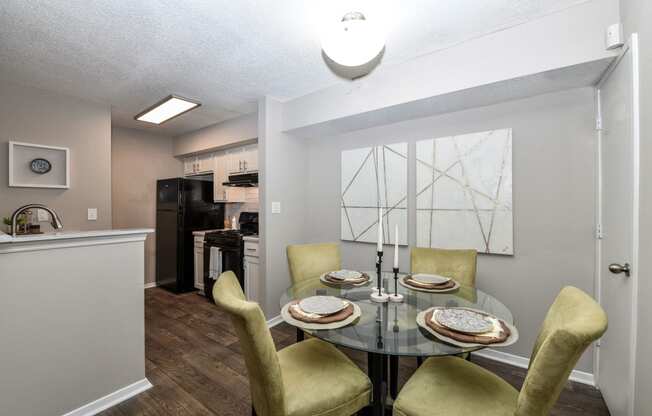 a dining area with a glass table and yellow chairs