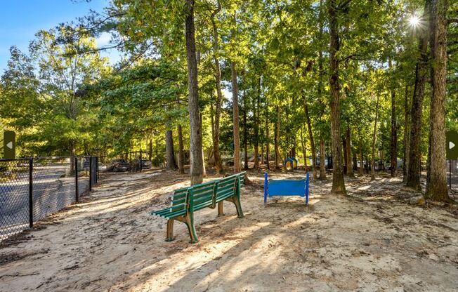 Dog park with wo benches in a park with trees at University Ridge Apartments, Durham, NC, 27707