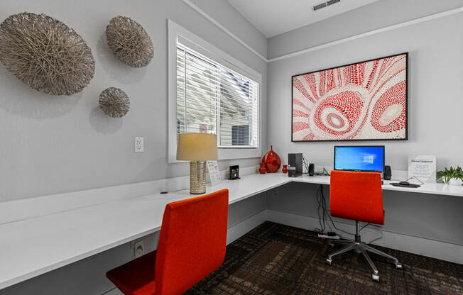 a home office with two red chairs and a desk with a computer