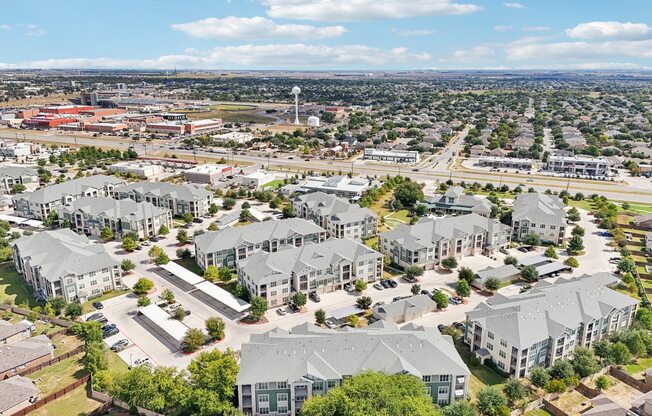 A bird's eye view of a residential area with multiple houses and a road.