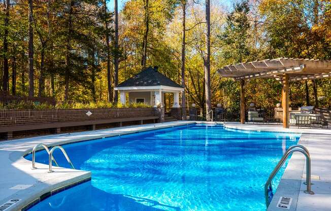 a swimming pool with a gazebo in the background