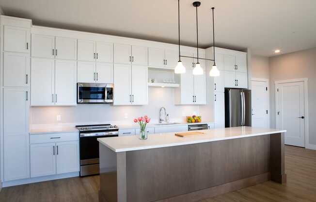 A modern kitchen with white cabinets and a central island.