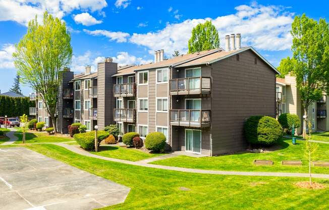 Apartment complex with a parking lot in front.