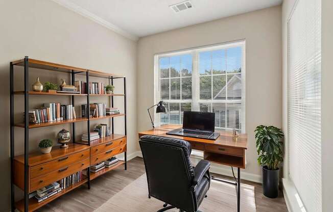 A room with a desk, chair, and bookshelf.
