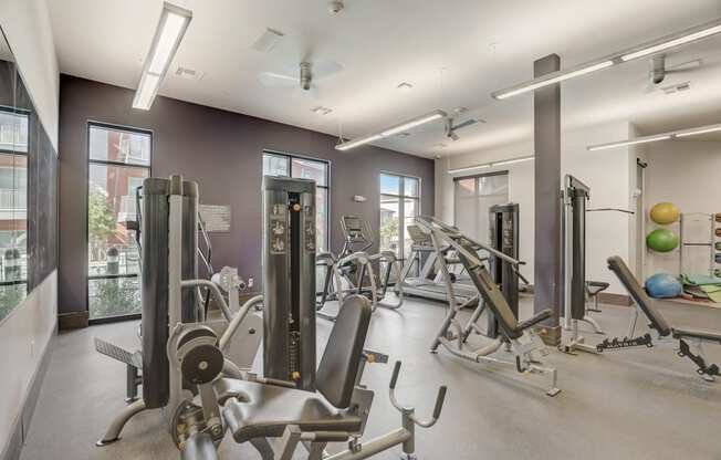 a gym with weights and cardio equipment at the district flats apartments
