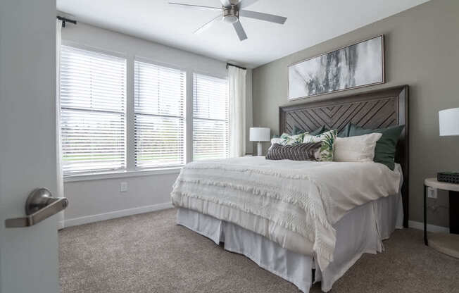 an empty bedroom with a bed and a ceiling fan
