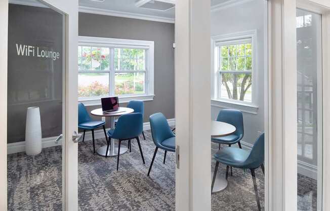 a conference room with blue chairs and a table with a laptop