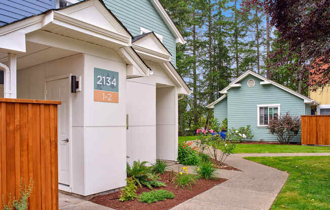 a white and blue house with a sidewalk in front of it at Woodcreek, Poulsbo Washington