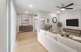 A modern living room with a white sofa and a wooden floor.
