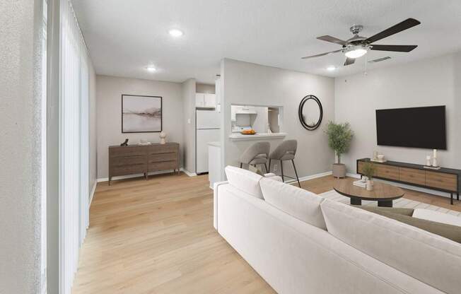 A modern living room with a white sofa and a wooden floor.