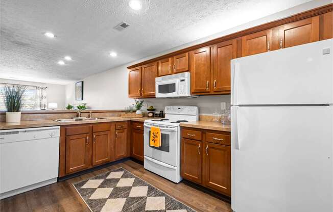 A kitchen with white appliances and wooden cabinets.