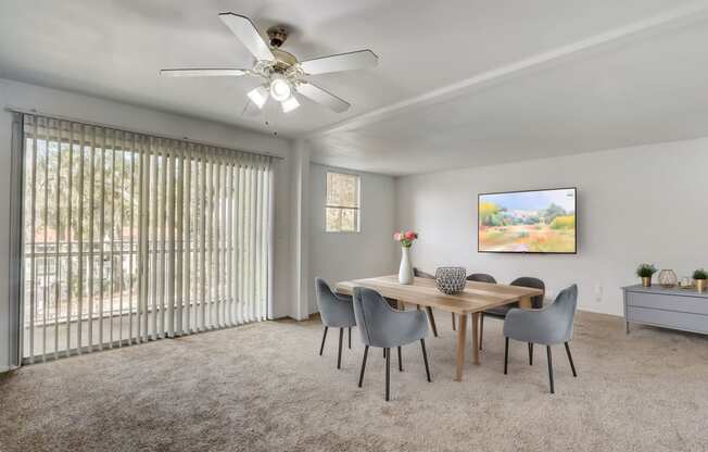 a dining room with a table and chairs and a ceiling fan