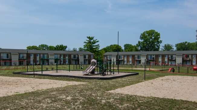 Outdoor sand volleyball court and playground at Pickwick Farms Apartments in Indianapolis, IN