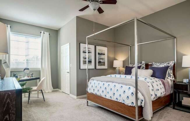 Bedroom with modern canopy bed, desk nook and natural light