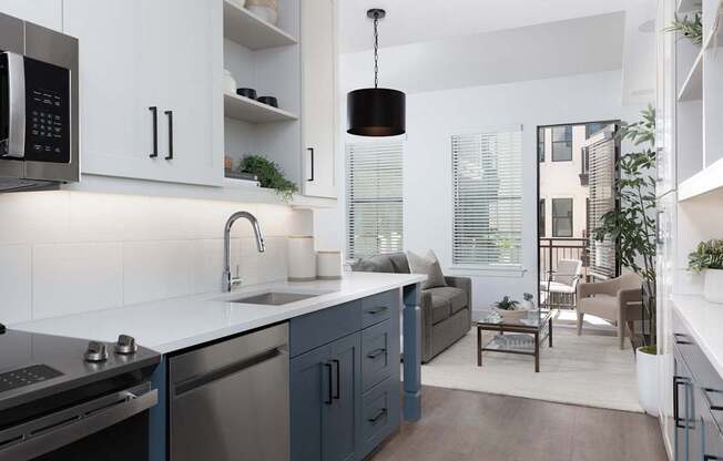 A modern kitchen with a white countertop and blue cabinets.