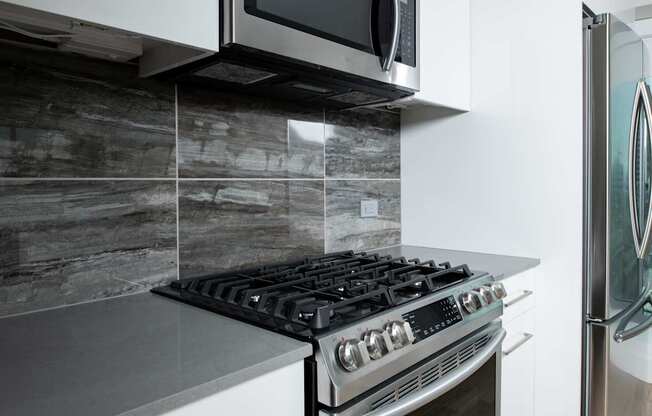 A modern kitchen with a stove and a microwave above it.