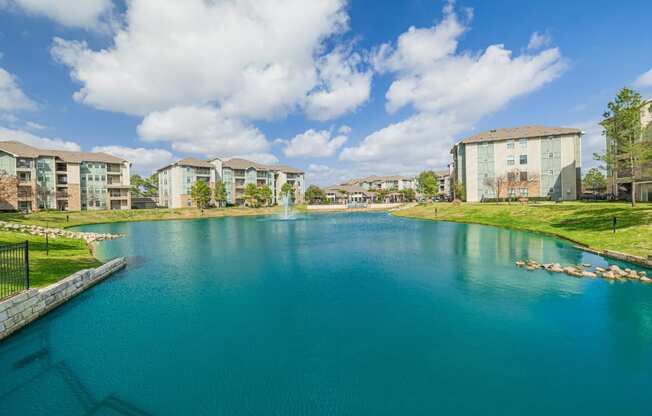 a large lake with apartments in the background
