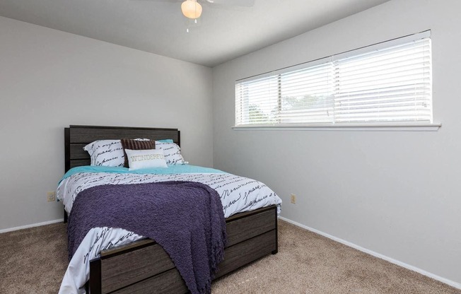 a bedroom with a bed and a large window