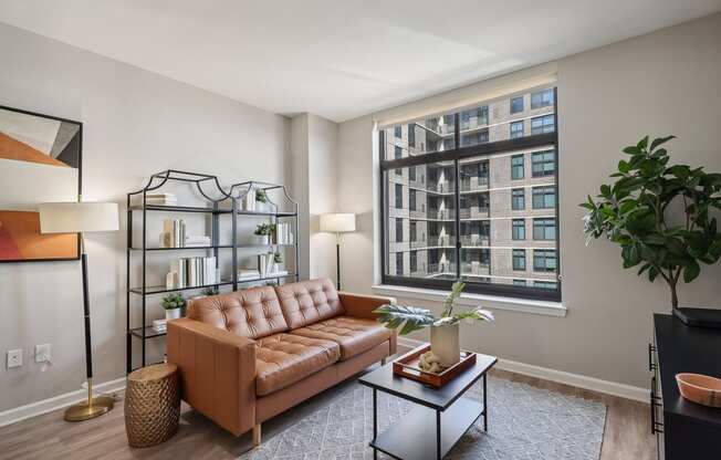 a living room with a brown couch and a large window