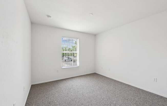 an empty room with white walls and a window