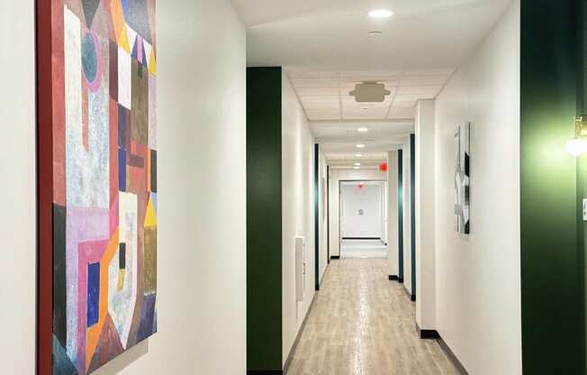 a hallway with a colorful painting on the wall and a corridor with green and white