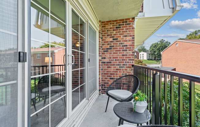 a patio with two chairs and a table on a balcony