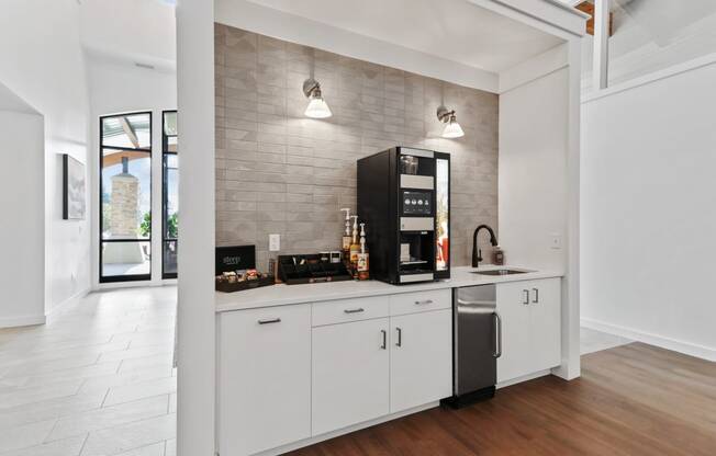 a kitchen with white cabinets and a black coffeemaker