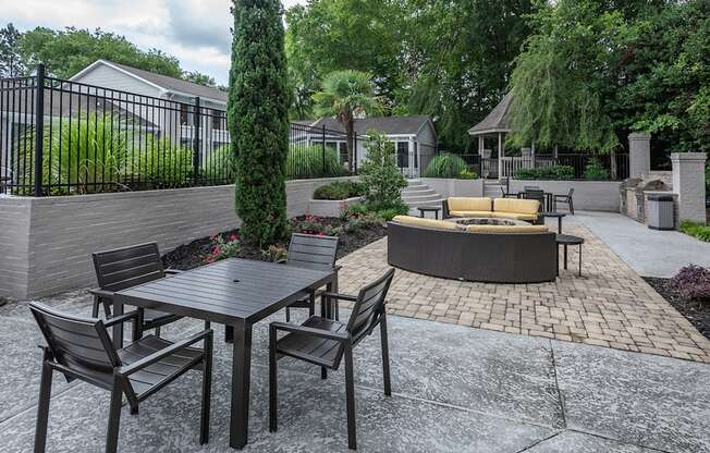 a patio with a table and chairs and a fire pit