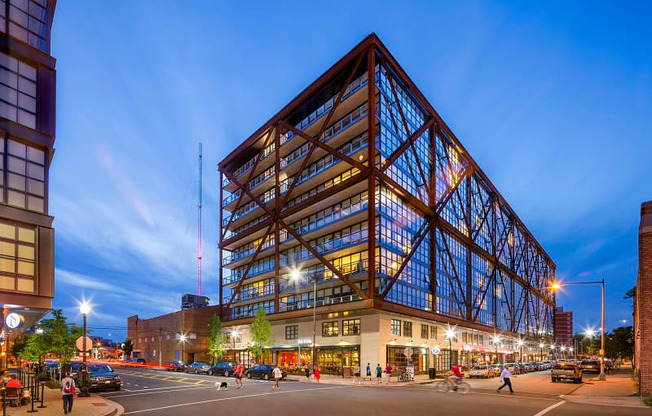 a large glass building on a city street at night