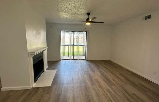 A room with a fireplace and a ceiling fan.