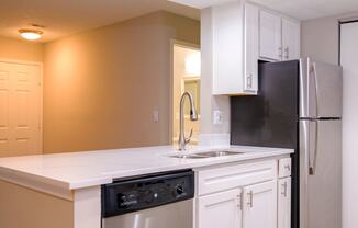 a kitchen with white cabinets and black appliances