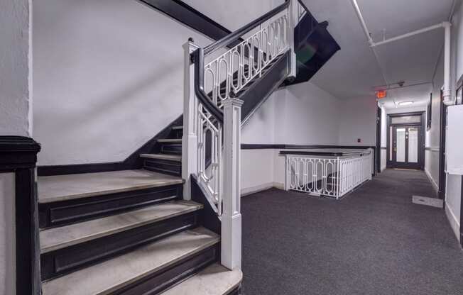 a stairwell in a building with a metal railing and carpeted floors