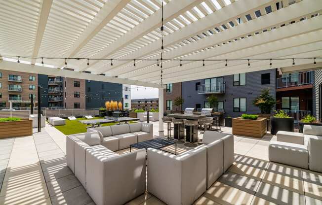 a lounge area with white couches and tables under a white roof at EagleRidge Plaza Residences, Fargo, North Dakota