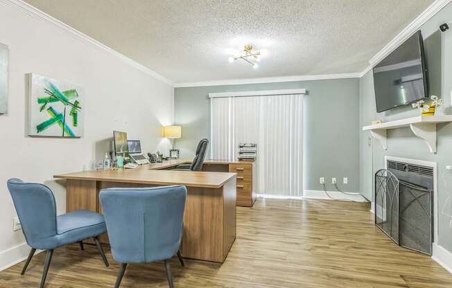 A room with a desk and two chairs.