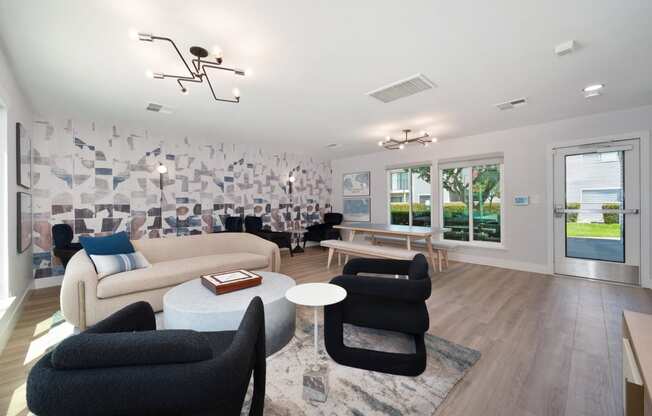 a lounge area with chairs and tables and a wall with a geo wallpaper at Silverstone Apartments, Davis, California