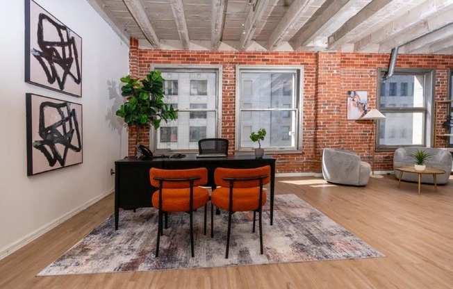 an office with a brick wall and a desk in front of a window