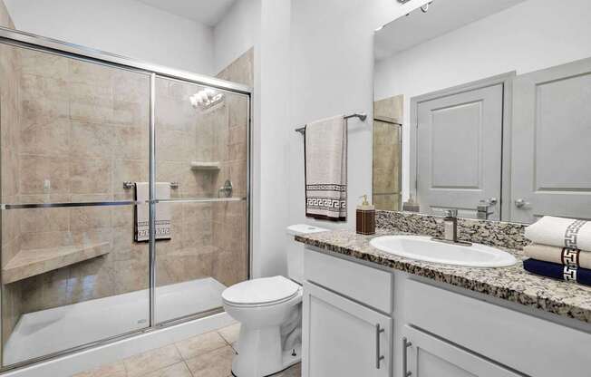 A bathroom with a toilet, sink, and shower.