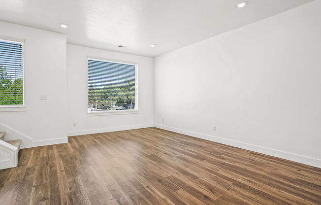 an empty living room with wood floors and a window  at Aero Luxury Townhomes in Layton, Utah