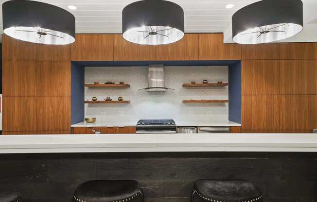 a kitchen with wood cabinets and a white counter top and black stools