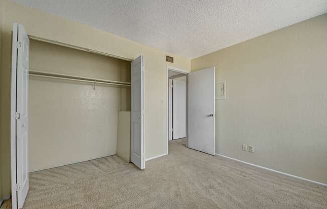 the living room of an apartment with a door to the closet