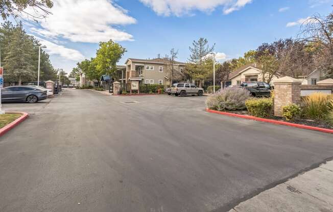 the view of a parking lot with houses on the side of the street