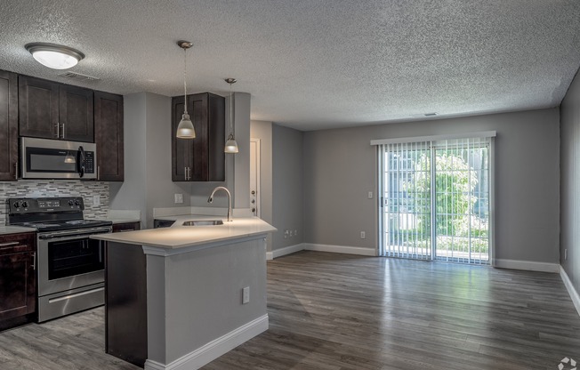 an empty kitchen and living room with a sliding glass door