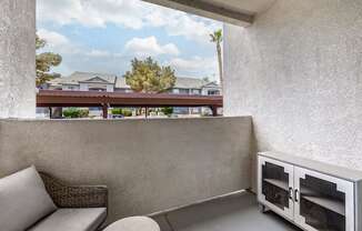 a balcony with a couch and a chair and a fireplace at Paisley and Pointe Apartments, Las Vegas, Nevada